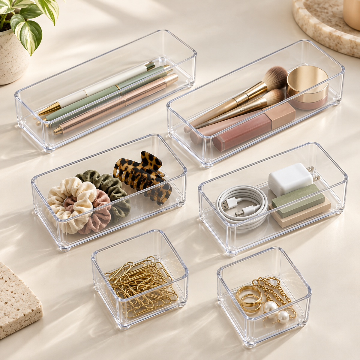 Six clear Yoaxo drawer trays in three sizes with small essentials